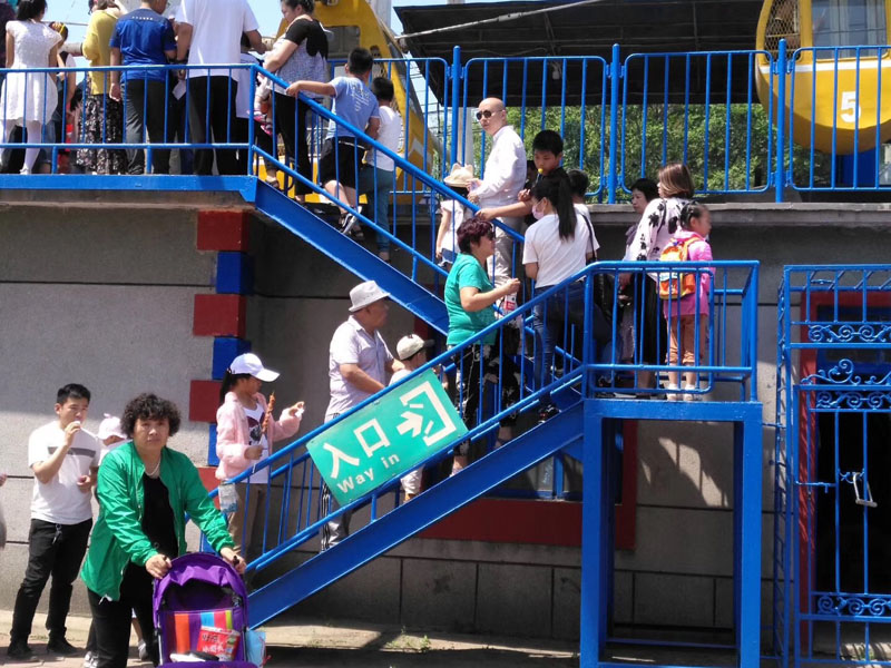 每年六一，陽陽（二樓緩步臺背書包女孩）都能在公園玩?zhèn)€痛快