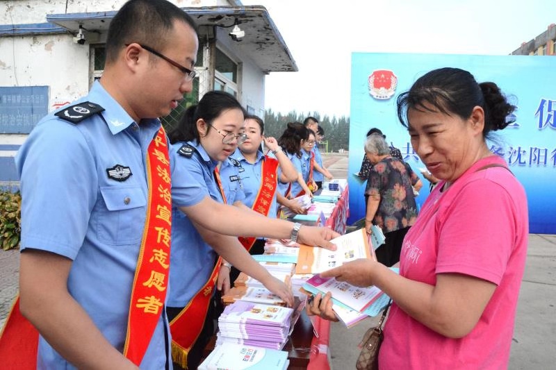 法治宣傳志愿者向市民發(fā)放宣傳手冊