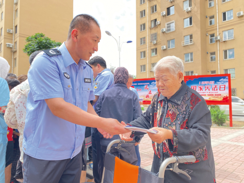 唐兵向?qū)O秀梅老人發(fā)法治宣傳手冊(cè)1