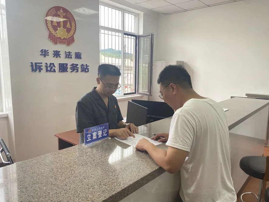 華來(lái)人民法庭訴訟服務(wù)站的工作人員指導(dǎo)當(dāng)事人寫起訴狀。