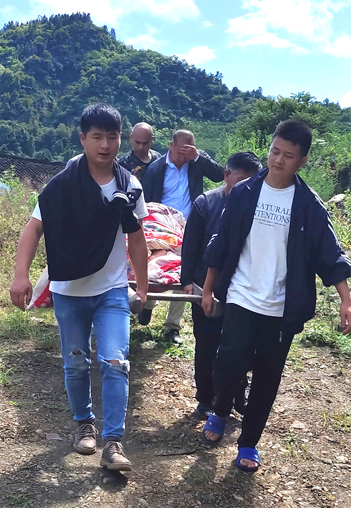 山高路遠，清水坪鎮(zhèn)網(wǎng)格員抬著擔(dān)架送患病的老人去醫(yī)院治病