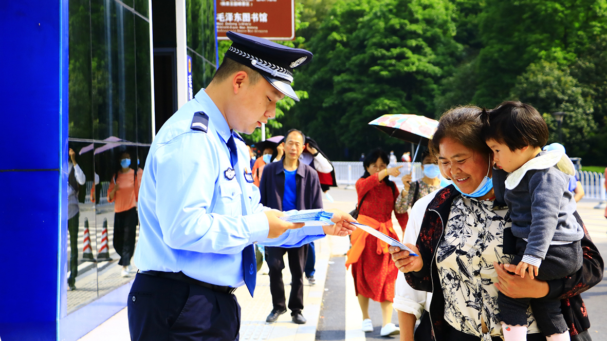 韶山?jīng)_派出所，民警向游客發(fā)放反詐宣傳單