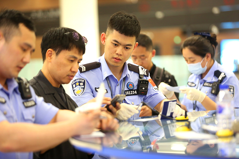 民警協(xié)助外國(guó)旅客填寫入境卡片。