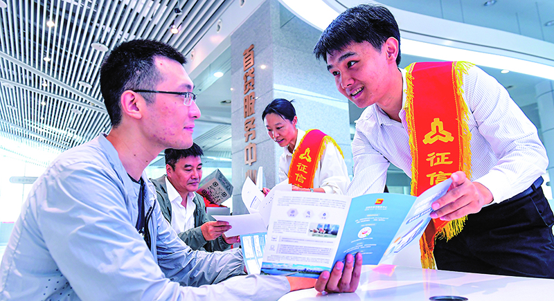 征信志愿服務(wù)大隊(duì)志愿者在首貸服務(wù)中心為前來(lái)咨詢(xún)征信業(yè)務(wù)的群眾進(jìn)行業(yè)務(wù)講解