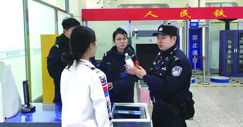 二題圖，童秋華（右）在向旅客講解安檢規(guī)定