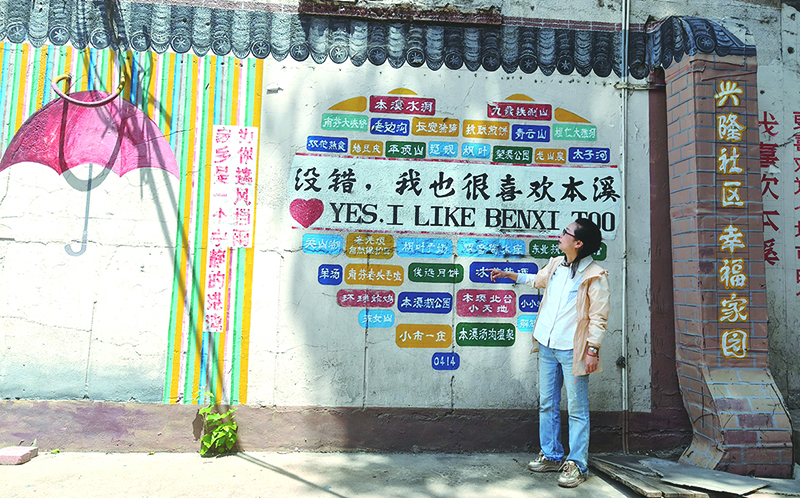 楊軼達向記者介紹社區(qū)的墻繪。