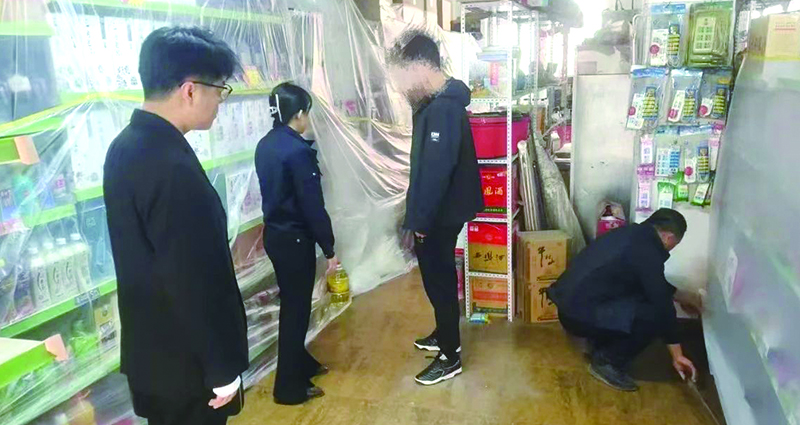 二圖，法院干警正在幫助一樓商戶粘貼防塵塑料布