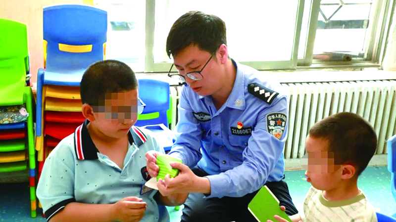 二題圖，民警在營口市金石自閉癥兒童幼兒園指導(dǎo)孩子制作粽子折紙